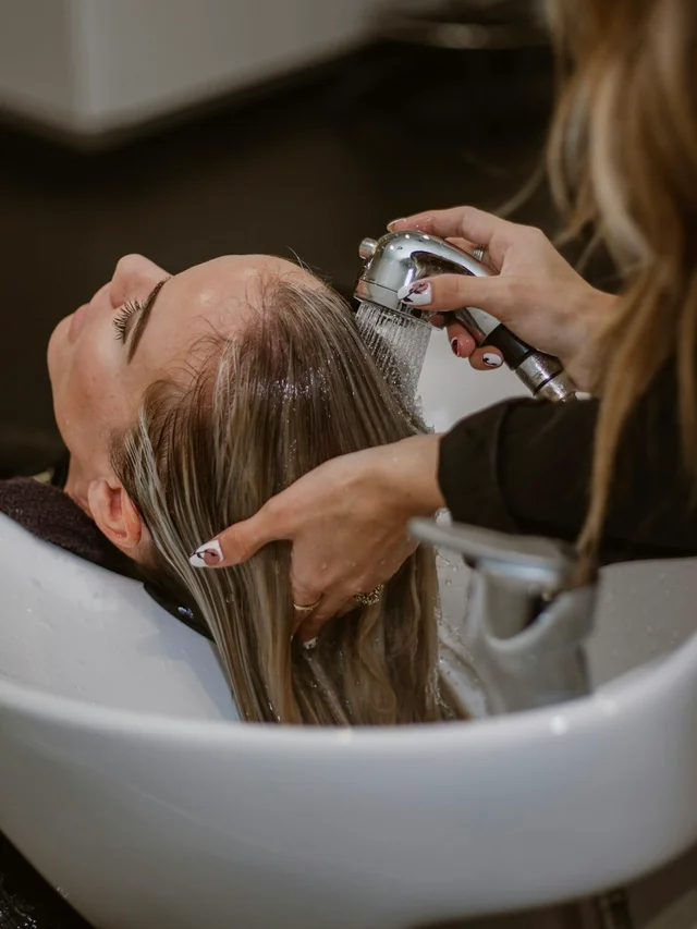 Estilista cortando el cabello de una clienta en salon