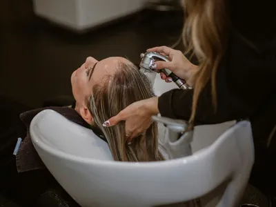 Estilista cortando el cabello de una clienta en salon